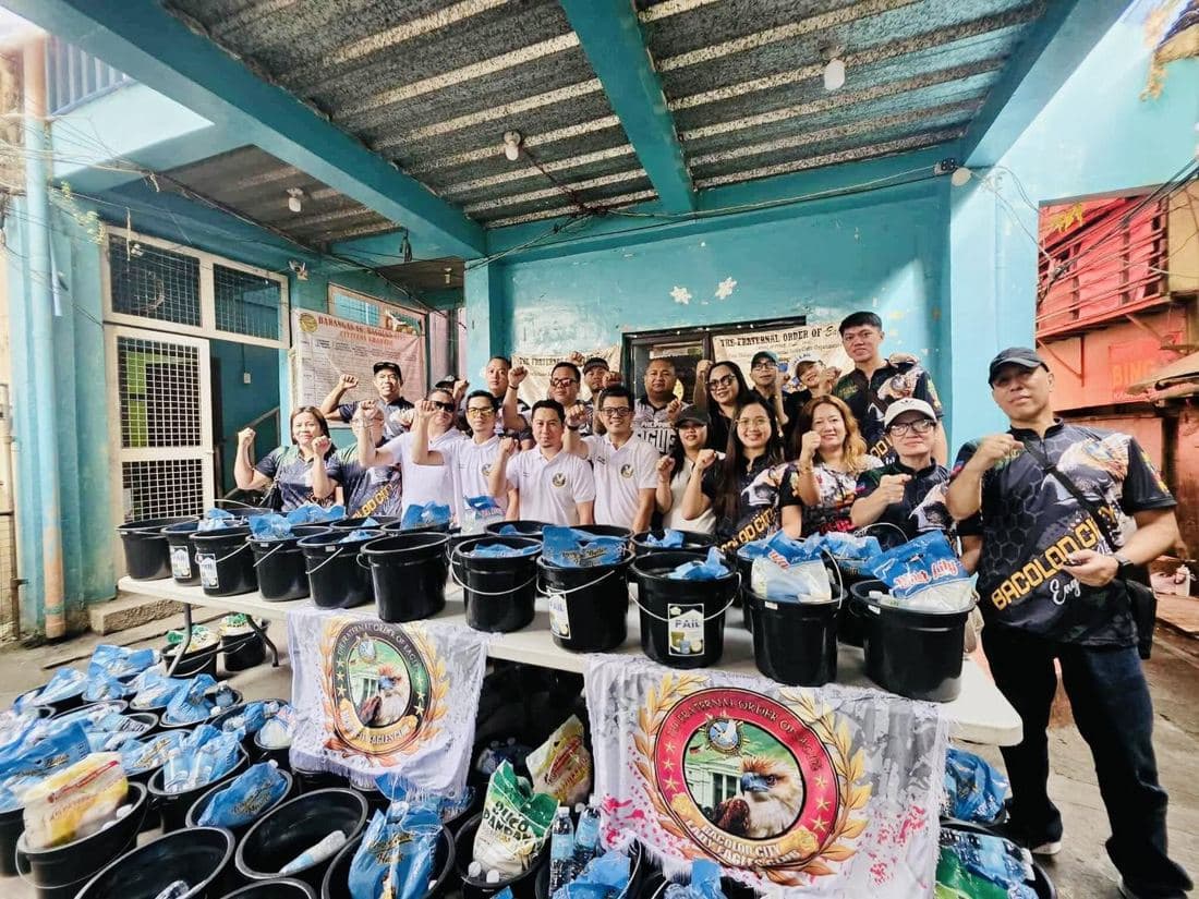 Bacolod City Eagles and Lady Eagles behind rows of relief buckets